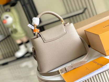 CAPUCINES BB 27 DARK BEIGE TAURILLON GOLD HARDWARE